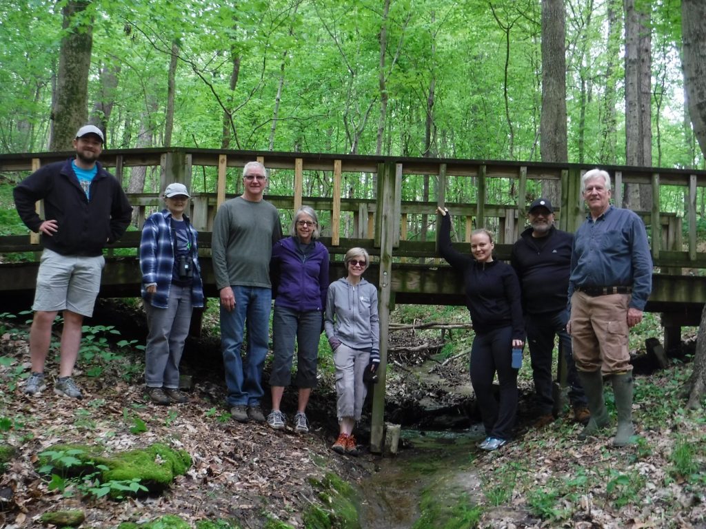 Group of people in front of bridge in forest